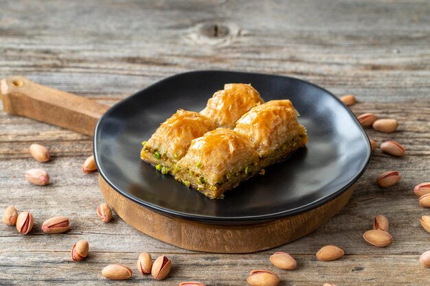 Foto pistachio baklava su uno sfondo di legno pistaccio baklava in stile turco presentazione e servizio vista orizzontale ravvicinata