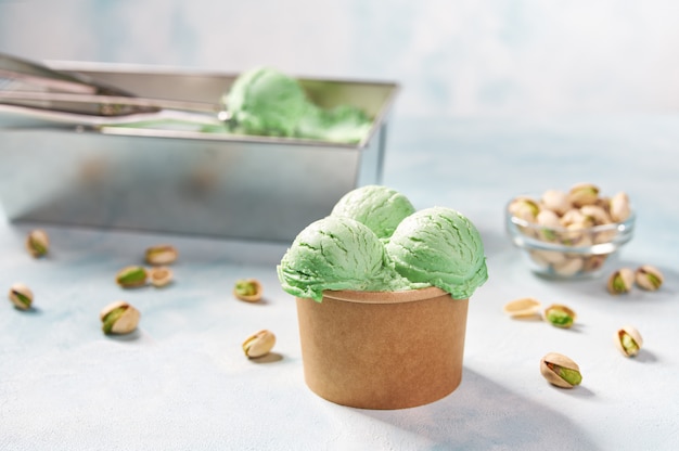 Photo pistachio ice cream scooped out of container, selective focus