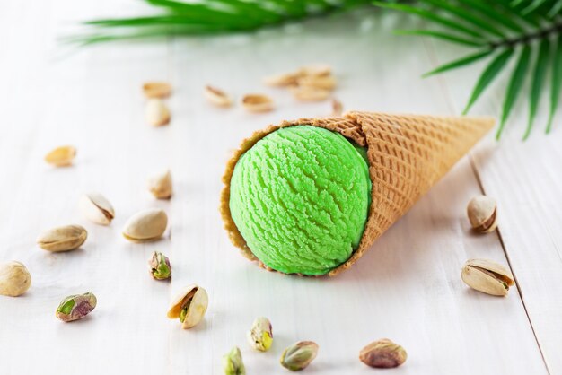 Pistachio ice cream with a branch of a palm tree on a wooden table