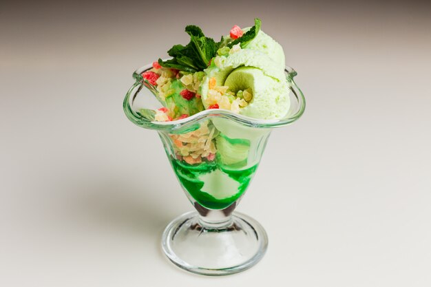 Pistachio ice-cream with candied fruits and green syrup