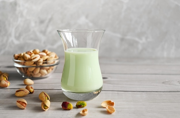 Pistachio milk in the glass on the wooden background This milk is a great source of antioxidants phytosterols and heart healthy fats