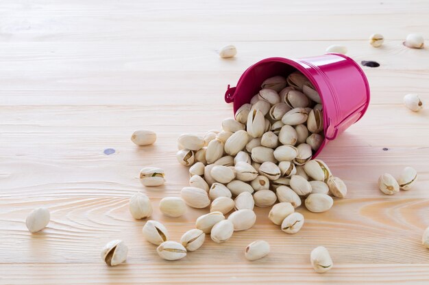 Pistachio nuts are lined on the wooden floor.