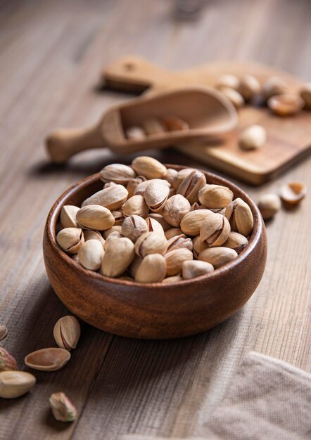 Pistachio nuts in a brown  bowl on a  wooden background. Macro and close up view image