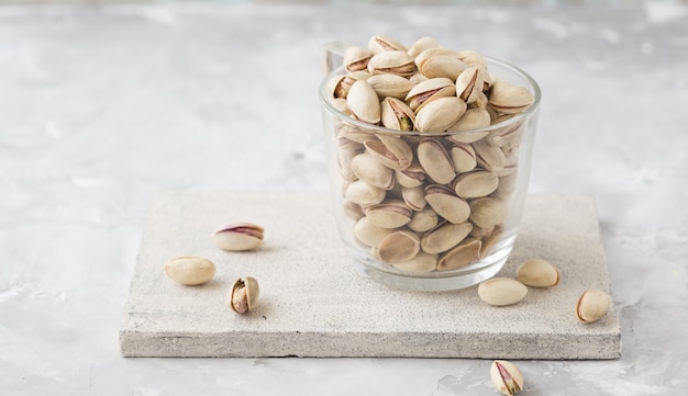 Pistachio nuts on concrete background. Roasted salted pistachios.