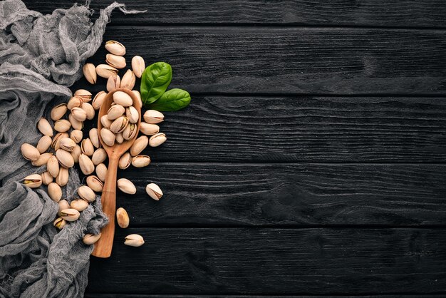 Pistachio nuts on a dark wooden background Healthy snacks Top view Free space for text