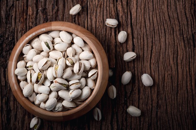 Pistachio nuts on old wood background, top view. snacks and Healthy nut concept