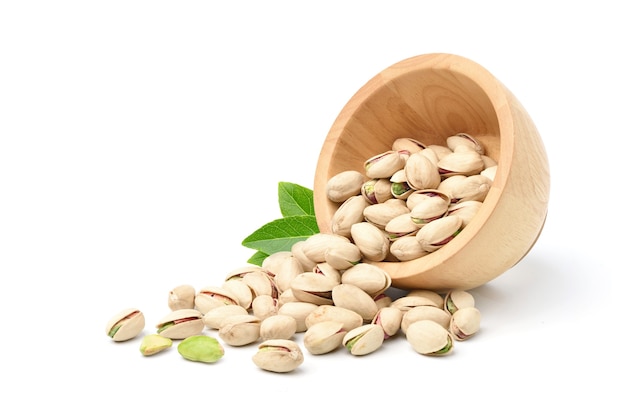 Pistachio nuts with wooden bowl isolated on a white surface