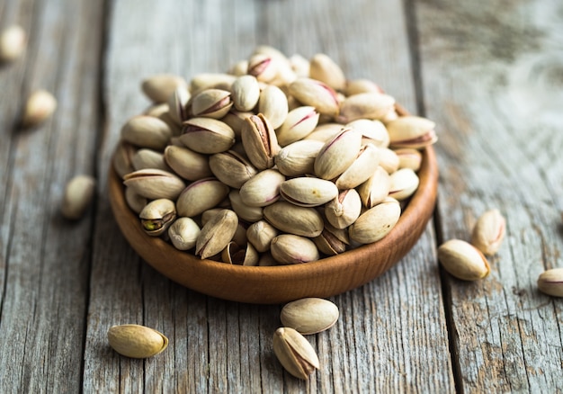 Pistachio nuts on wooden bowl