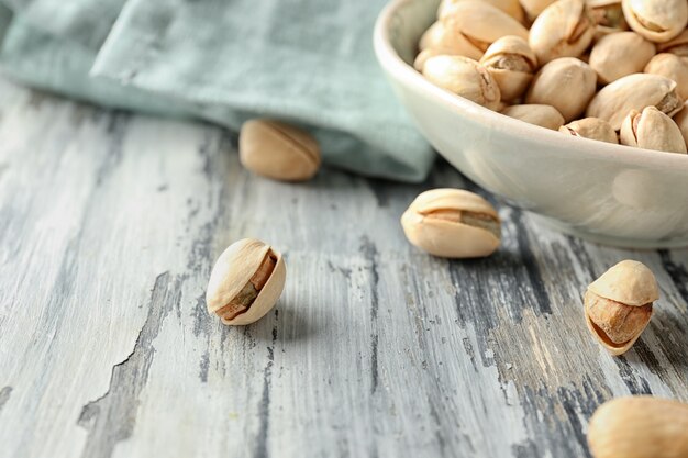 Pistachio nuts on wooden table, closeup