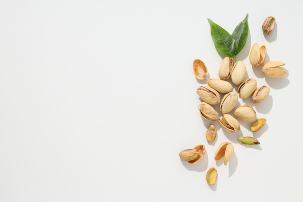 Pistachio's in de schelp met bladeren op een lichte achtergrond