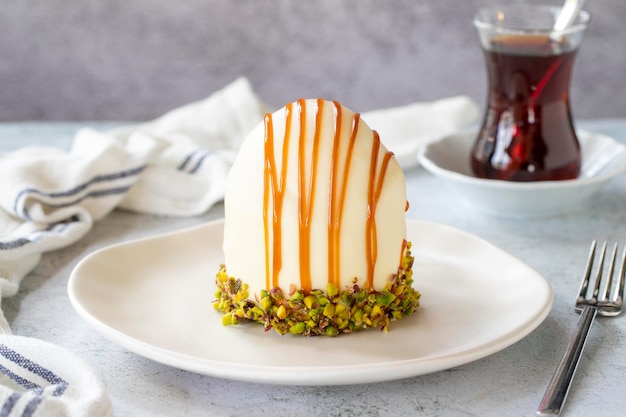 Pistachio and white chocolate cake on a gray background Fruit and cream cake covered with chocolate on the outside close up