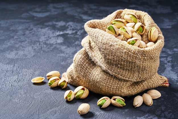 Pistacchi in borsa sulla tavola nera. mucchio o pila di pistacchi.