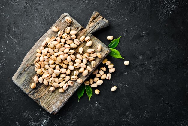 Pistachios on a black background Top view Free space for your text