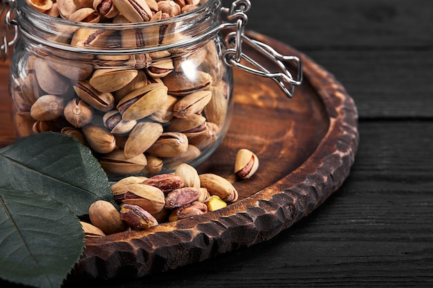 Pistachios nuts on dark background, top view, healthy snack.