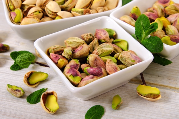 Pistachios in white square bowl close up