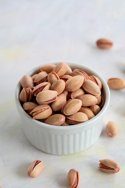 Pistachios on a white wooden background
