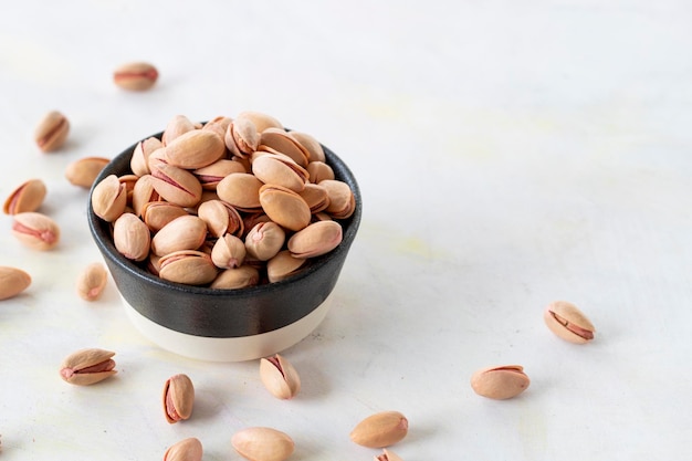 Pistachios on a white wooden background