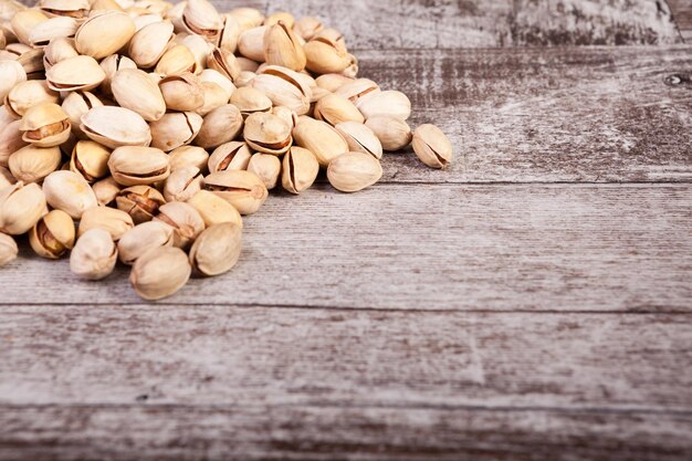 Pistachios on wooden background in studio photo with copyspace available. Healthy delicious snacks