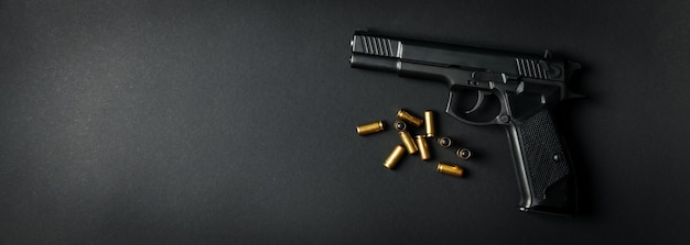 Pistol and traumatic bullets on black. Self defense weapon