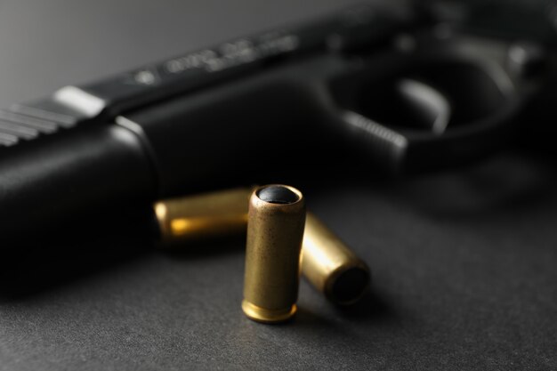 Pistol and traumatic bullets on black. Self defense weapon