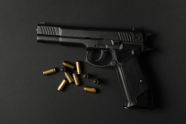Photo pistol and traumatic bullets on black. self defense weapon
