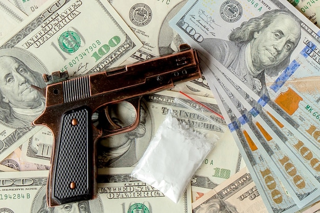 Pistols and drugs against the background of dollars.