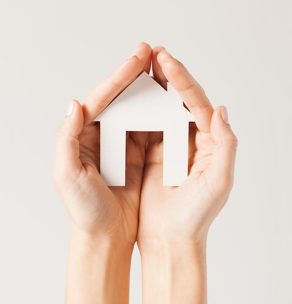 pisture of woman hands holding paper house