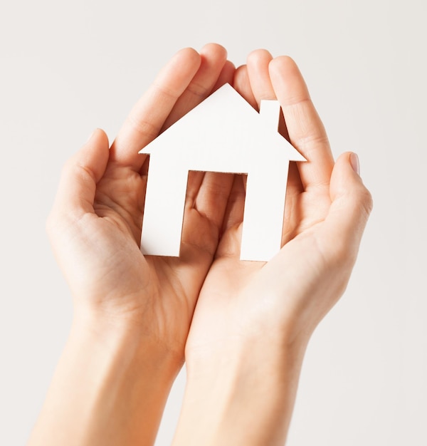 pisture of woman hands holding paper house