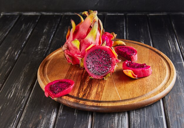 Pitahaya Cut and one whole on a wooden stand