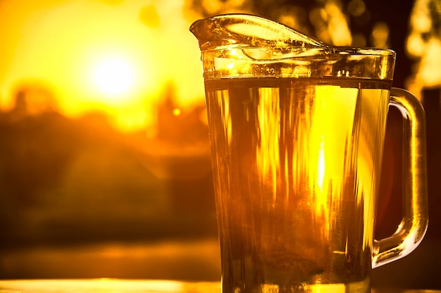 Brocca d'acqua fresca che spara contro la luce su un bel tramonto.