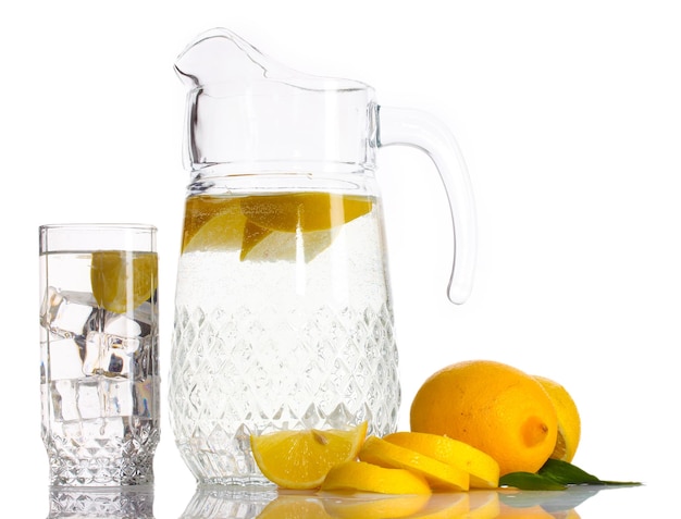 Pitcher and glass of lemonade and lemon isolated on white