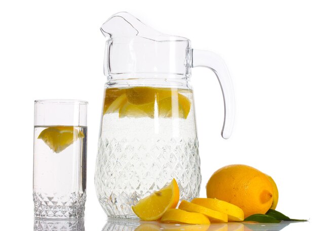 Pitcher and glass of lemonade and lemon isolated on white