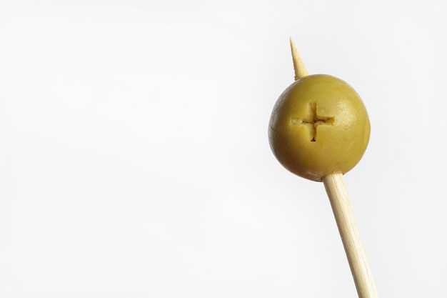 Pitted green olive on wooden stick