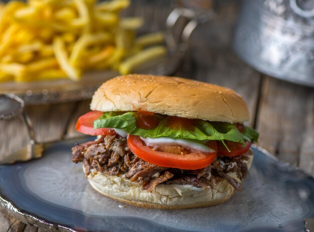 Pittig krokant rundvlees Shoarma Burgerserved in schotel zijaanzicht op houten tafel achtergrond