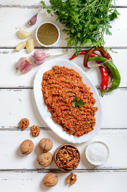 Pittige adjika en ingrediënten op een witte houten achtergrond bovenaanzicht Georgische keuken