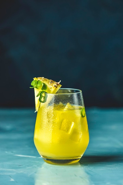 Pittige ananas jalapeno mezcalita of margarita voor Cinco de Mayo is een verfrissende cocktail gemaakt met ananas, koriander jalapeno en Mexicaanse gedistilleerde alcoholische drank Blauw betonnen oppervlak