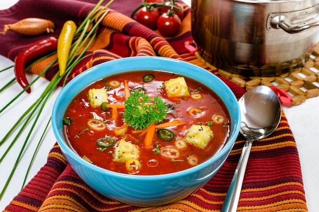 Foto pittige chili hete tomatensoep met broodblokjes in een kom.