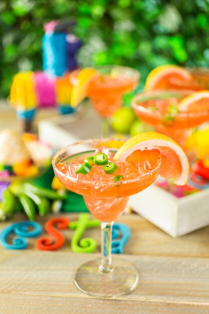 Pittige grapefruit margarita op ijs in margarita glazen op tafel in de tuin.