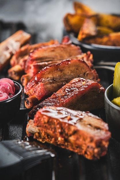 Pittige hete gegrilde spareribs van een zomerse bbq geserveerd met een aardappel en picles