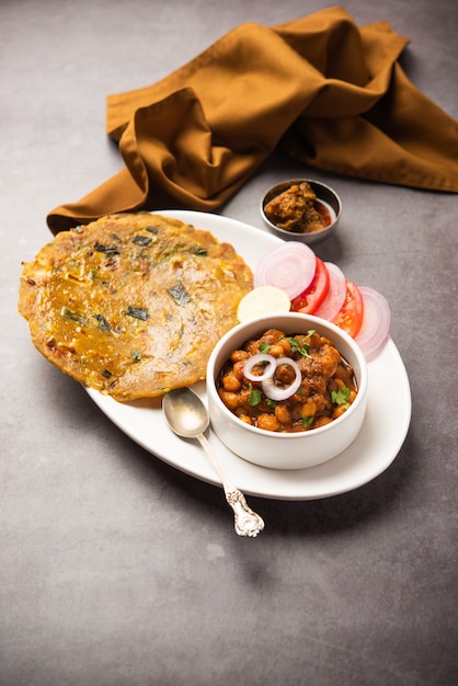 Pittige kikkererwten masala of chole curry met Pyaj Paratha of lente-ui Parantha en mango augurk