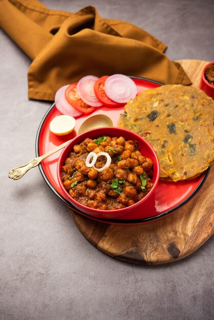 Pittige kikkererwten masala of chole curry met Pyaj Paratha of lente-ui Parantha en mango augurk