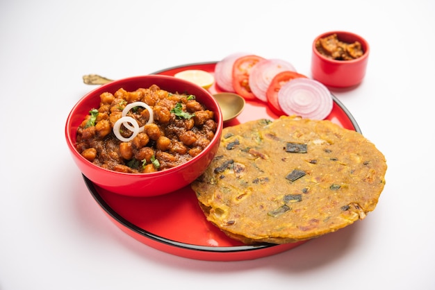 Pittige kikkererwten masala of chole curry met Pyaj Paratha of lente-ui Parantha en mango augurk