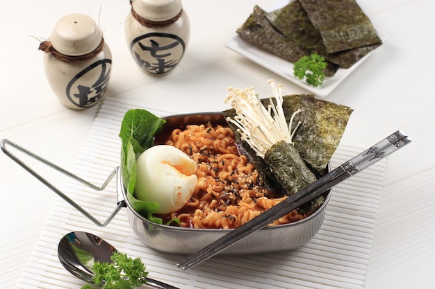 Pittige Koreaanse Instant Ramen of Ramyun met zachtgekookt ei, champignons en nori-laver. Gegarneerd met sesamzaad