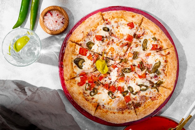 Pittige pizza met kippentomaten en jalapenos op het lichtgrijze bovenaanzicht als achtergrond