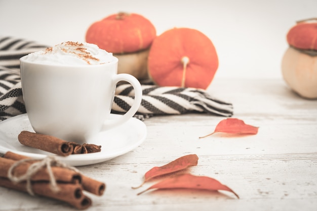 Pittige pompoen latte koffie, herfst warme drank witte kop, met pompoenen, kaneel en kruiden