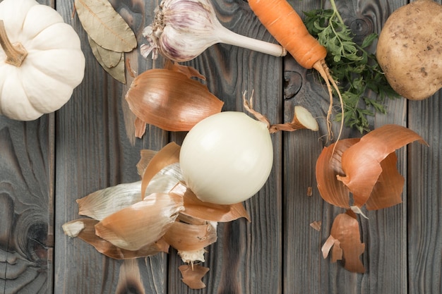 Pittige witte ui schillen Plat lag weergave Verse rauwe groenten en smaakstoffen Ui villen op houten keukentafel