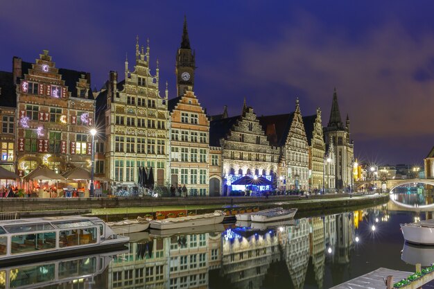 Pittoresk middeleeuws gebouw aan de kade Graslei in de rivier de Leie in de stad Gent 's avonds, België