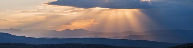 Pittoreske zonsondergang in de zonnestralen van de bergen