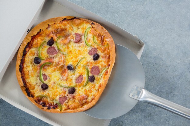 Pizza being placed in a box