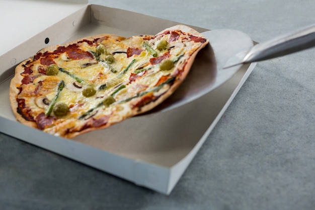 Pizza being placed in a box